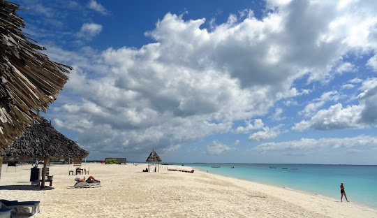 Zanzibar beach with thatched umbrella and turquoise water